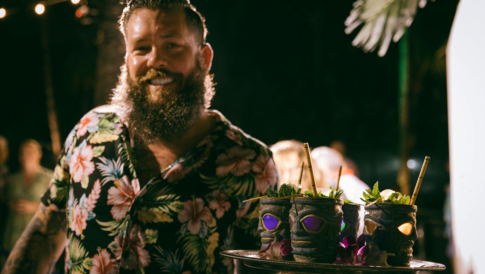 Server with cocktails in tiki glasses at food & wine event at Kimpton Surfcomber Hotel
