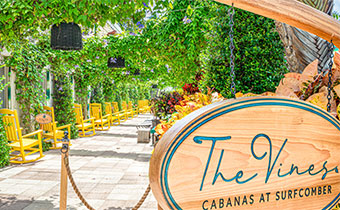 Entrance to the vines cabana area with yellow adirondack chairs at Kimpton Surfcomber Hotel